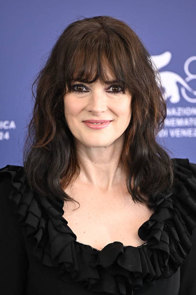 Winona Ryder posing in a ruffled dress at an event