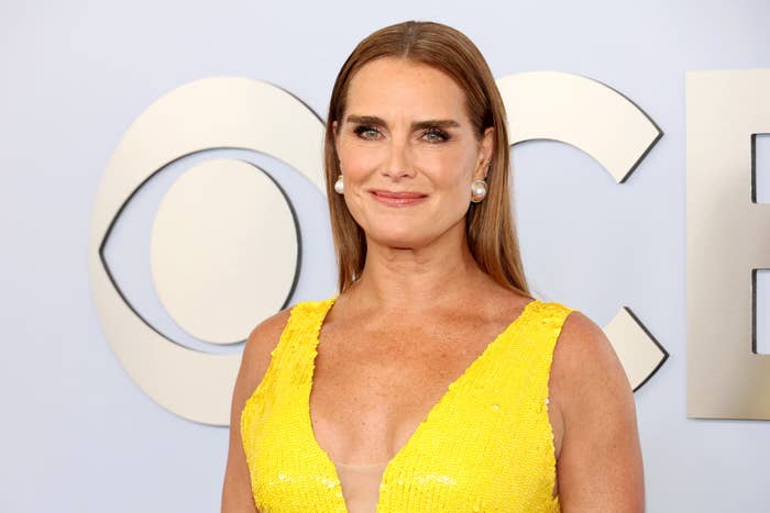 Brooke Shields on the red carpet in a sleeveless, plunging dress with pearl earrings