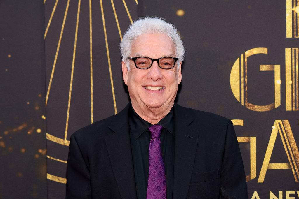 Marc Summers on the red carpet in a suit with bright tie, smiling at the camera