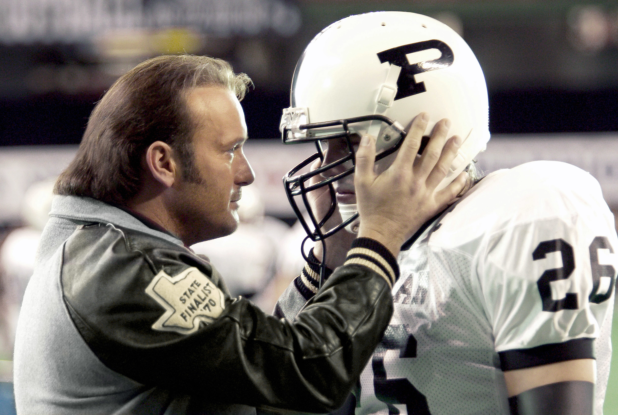 Coach Gary Gaines holds the helmet of Permian High's quarterback, inspiring him before a game in the movie &quot;Friday Night Lights.&quot;