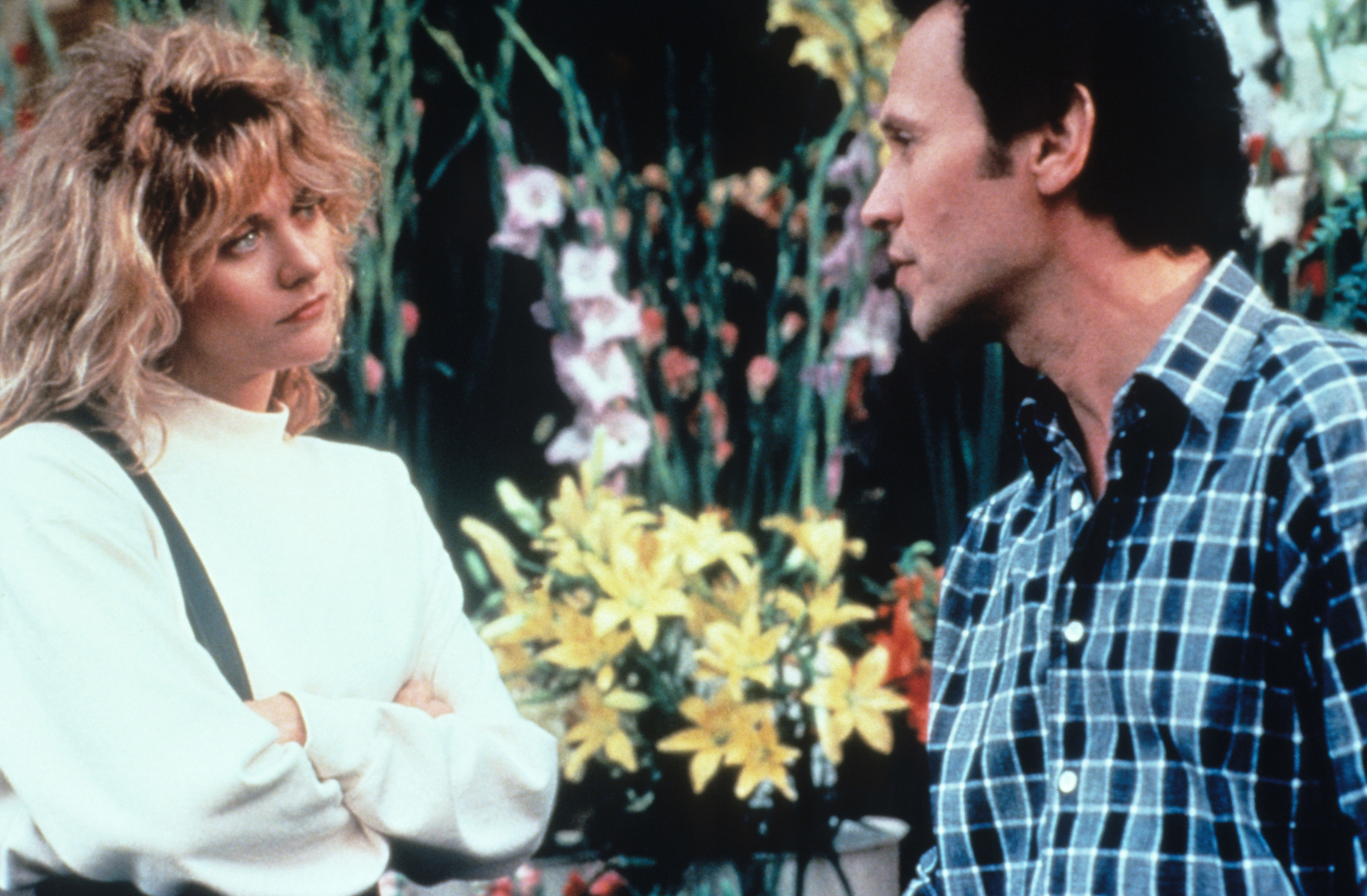 Meg Ryan and Billy Crystal in casual clothes, engaging in a conversation amidst a floral shop setting