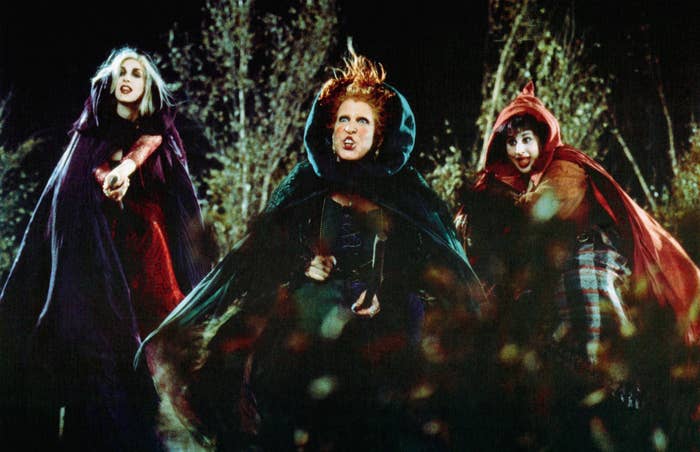 Bette Midler, Sarah Jessica Parker, and Kathy Najimy as Sanderson sisters in witch costumes, pointing and looking fierce in a scene from &quot;Hocus Pocus.&quot;