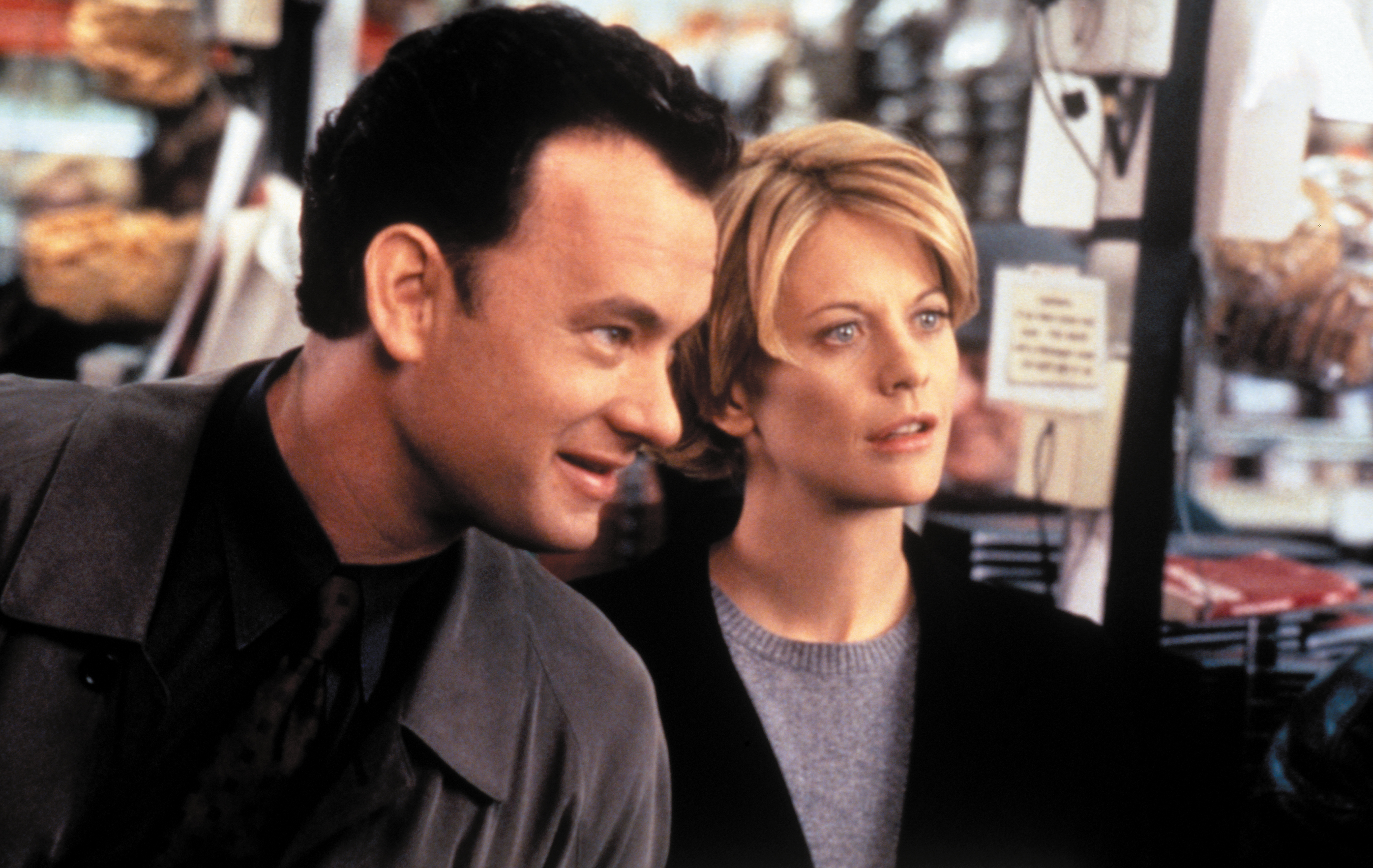 Tom Hanks and Meg Ryan in a scene from the movie &quot;You've Got Mail,&quot; looking ahead with expressions of interest inside a store