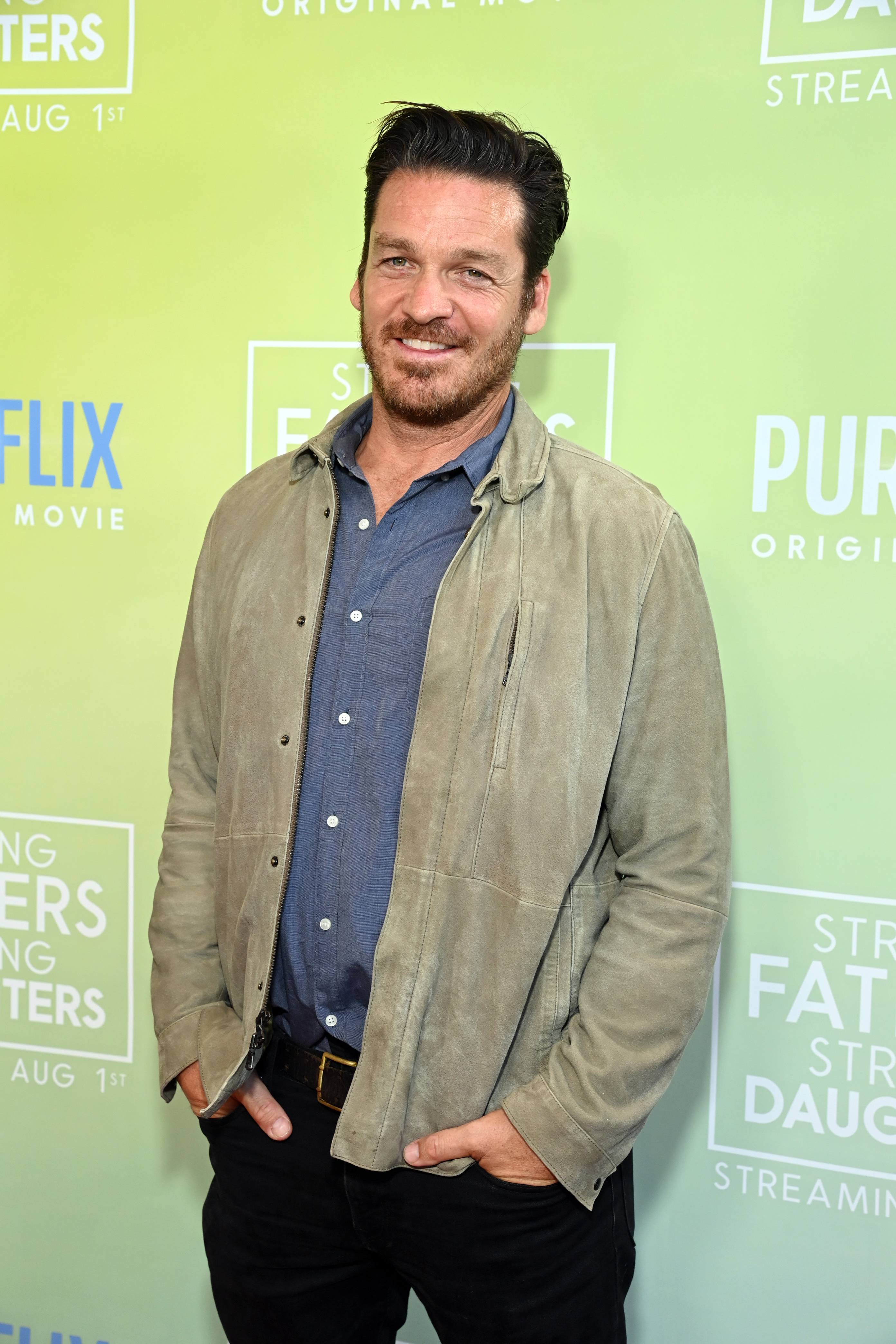 Bart poses in a casual jacket and blue shirt at the premiere of 'Strong Fathers, Strong Daughters'