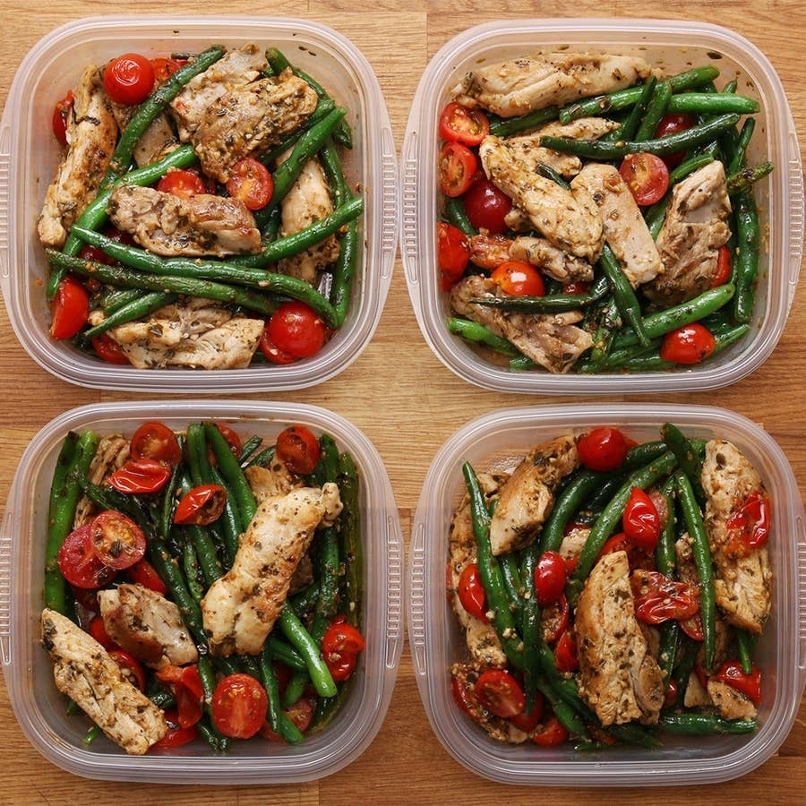 Meal prep containers with grilled chicken, green beans, and cherry tomatoes