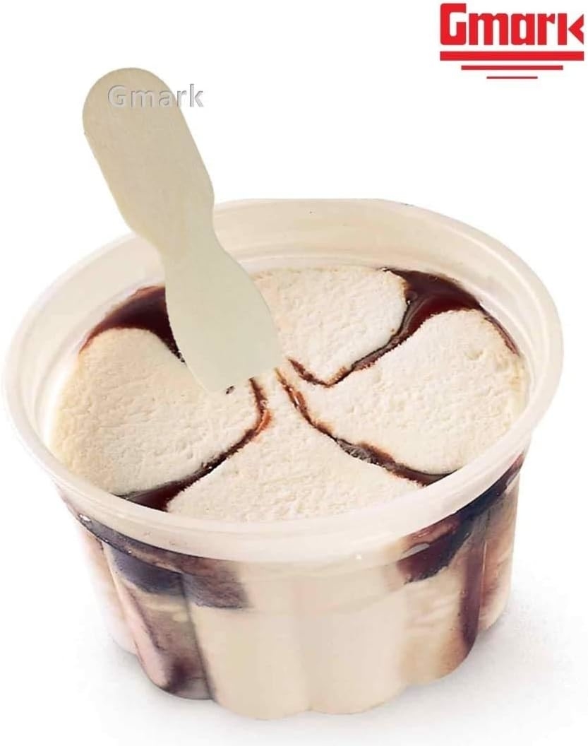 A small plastic cup filled with vanilla ice cream featuring swirls of chocolate syrup. The Gmark logo is visible in the top right corner