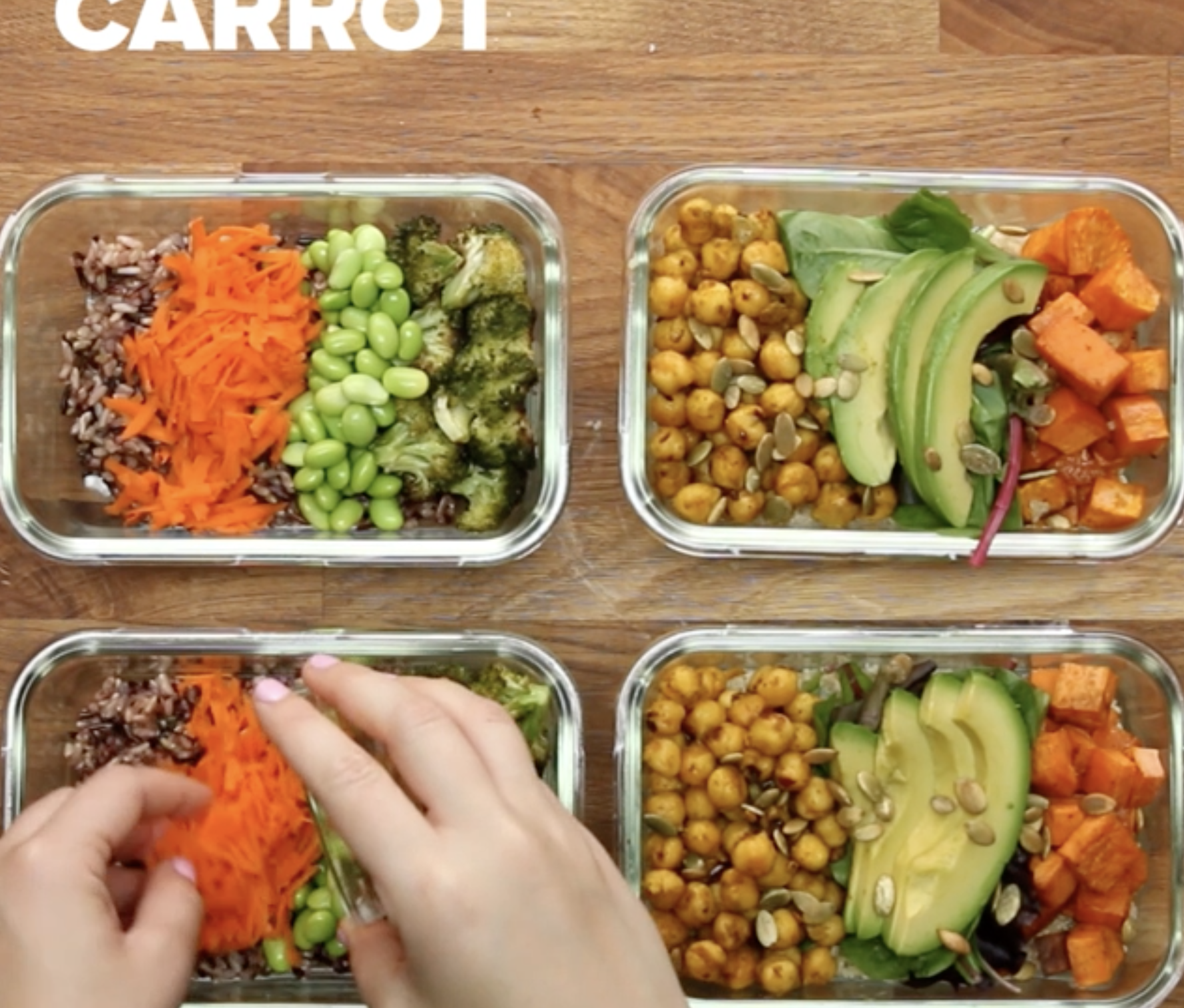 Four glass meal prep containers are filled with various healthy ingredients, including shredded carrots, edamame, broccoli, chickpeas, avocado, sweet potatoes, and greens