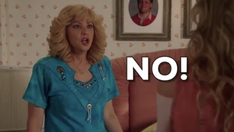 Wendi McLendon-Covey, in an exaggerated shocked expression, stands in a bedroom. The word "NO!" is written in bold letters