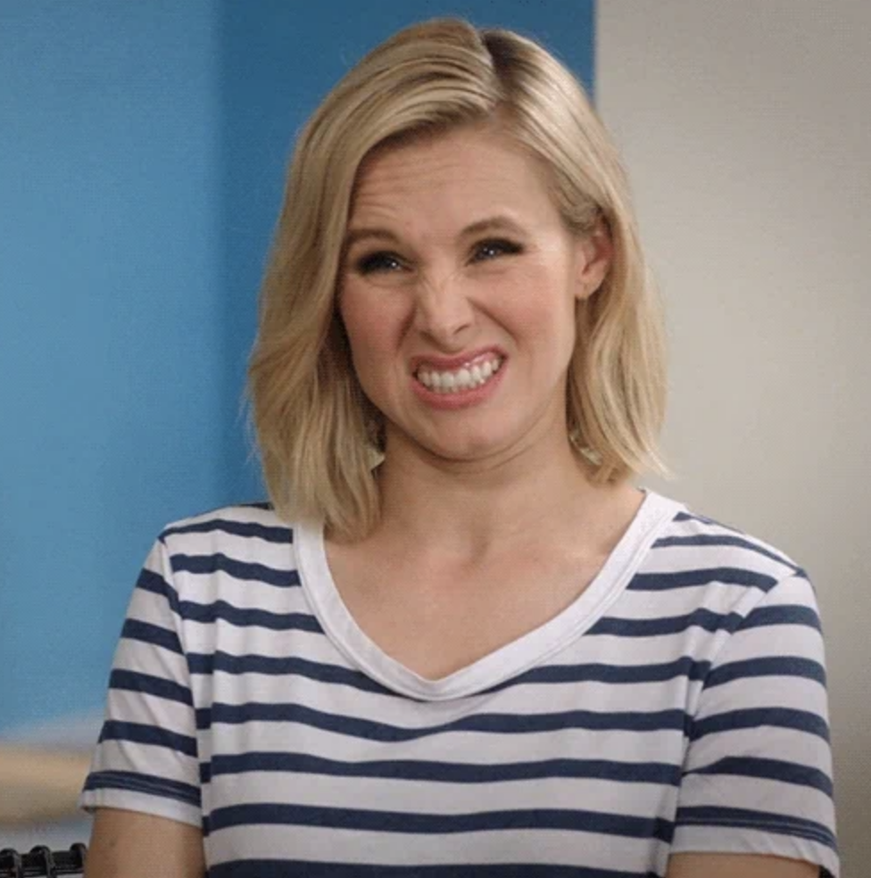 Kristen Bell smiling awkwardly in a striped shirt