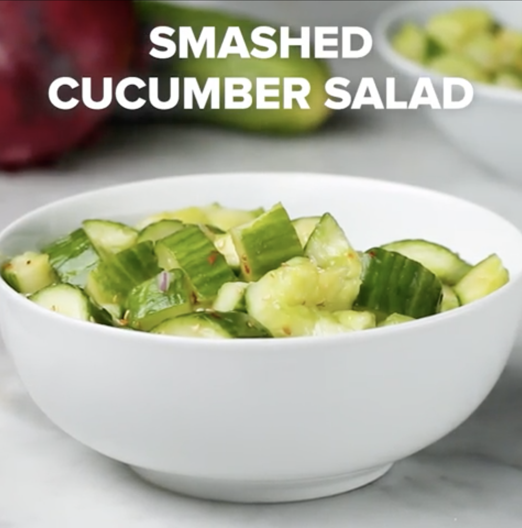 A white bowl filled with smashed cucumber salad, with text above reading &quot;Smashed Cucumber Salad.&quot;