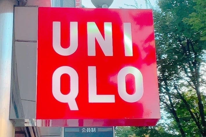 UNIQLO store signage on a building exterior with trees visible in the background