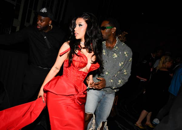 Cardi B in a striking gown with Offset in a floral shirt and ripped jeans at a celebrity event