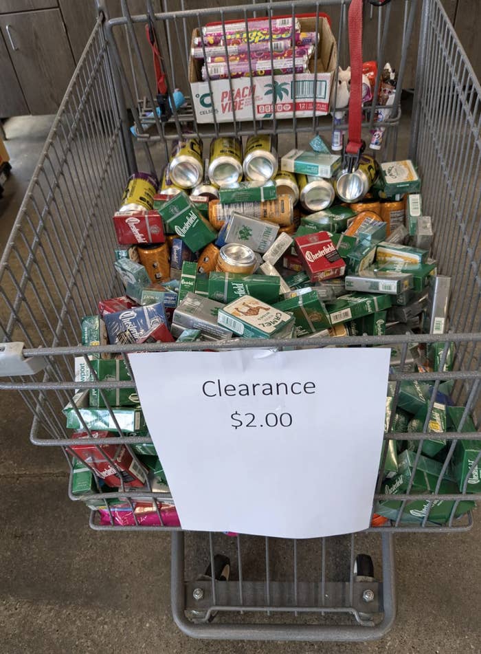 Shopping cart filled with various tobacco and vaping products. A clearance sign on the cart reads, "Clearance $2.00."