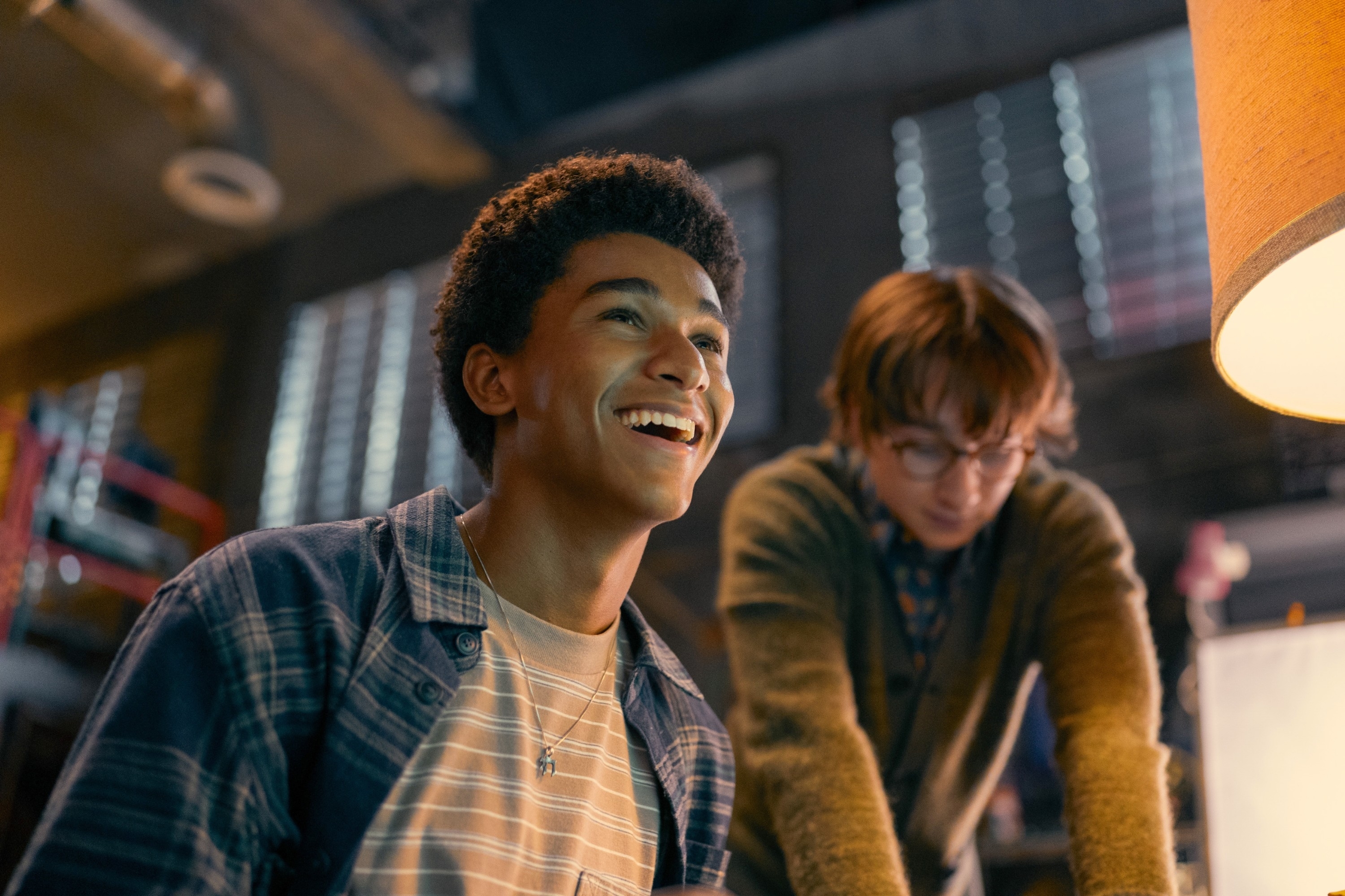 Jaden Michael and Adrian Greensmith in a casual indoor setting; Jaden is smiling while Adrian looks focused on something off-camera