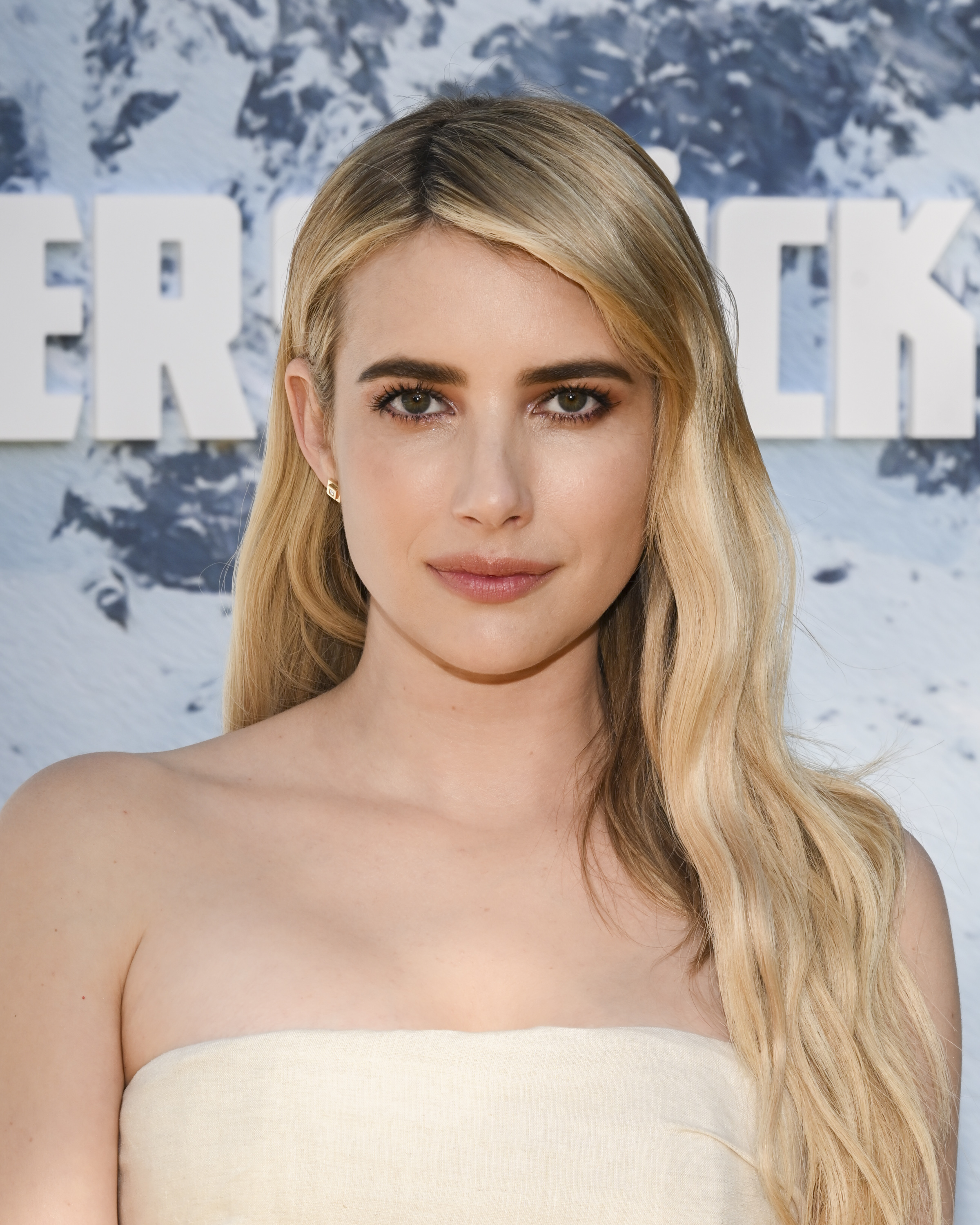 Emma Roberts posing in a strapless dress at a celebrity event
