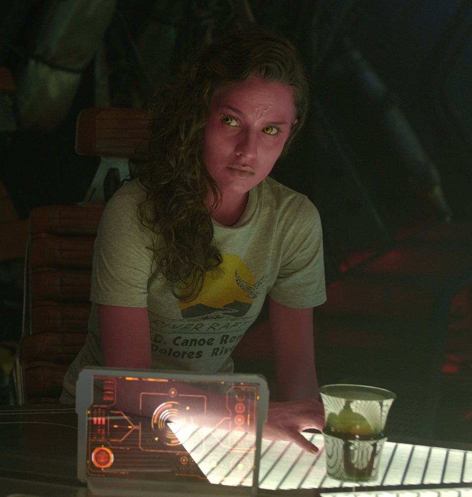 Melia Kreiling sitting at a table with futuristic items in "Guardians of the Galaxy"