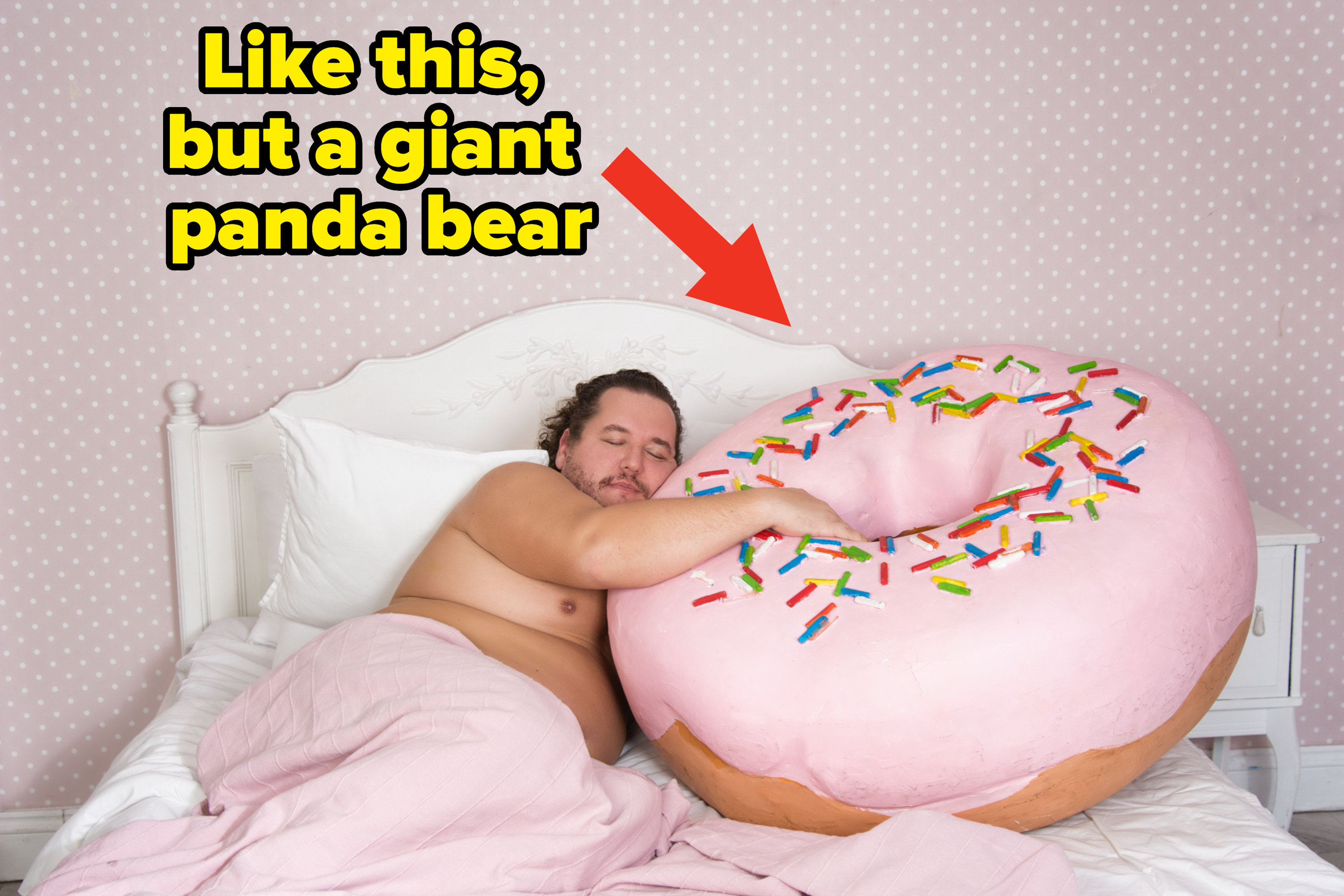 A man cuddles a giant donut pillow while lying in bed