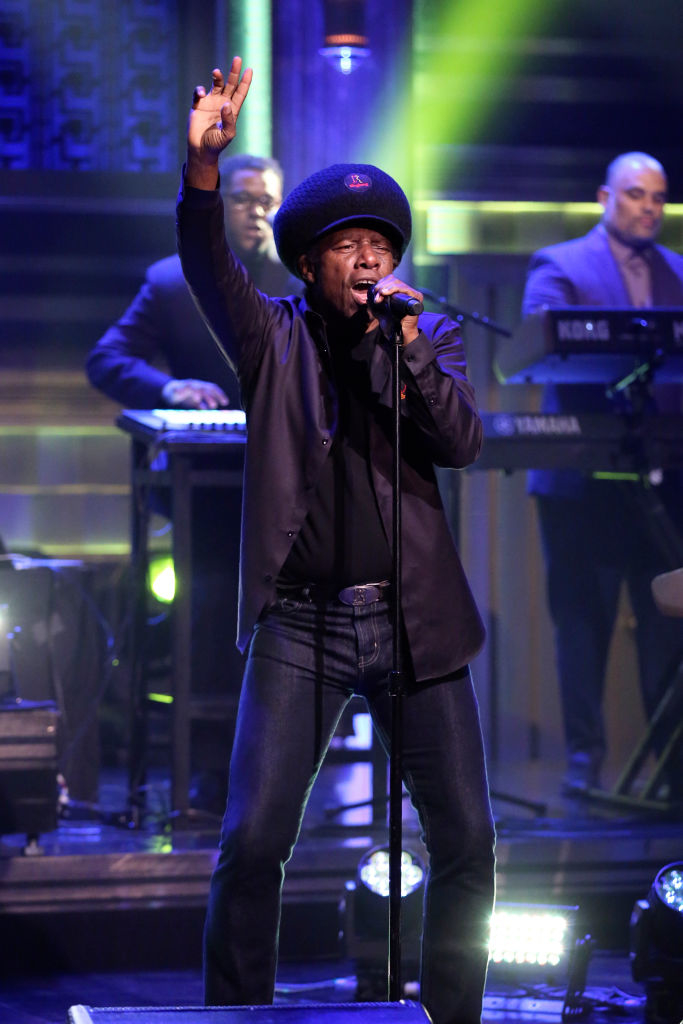 Eddy Grant on stage performing with a band behind him