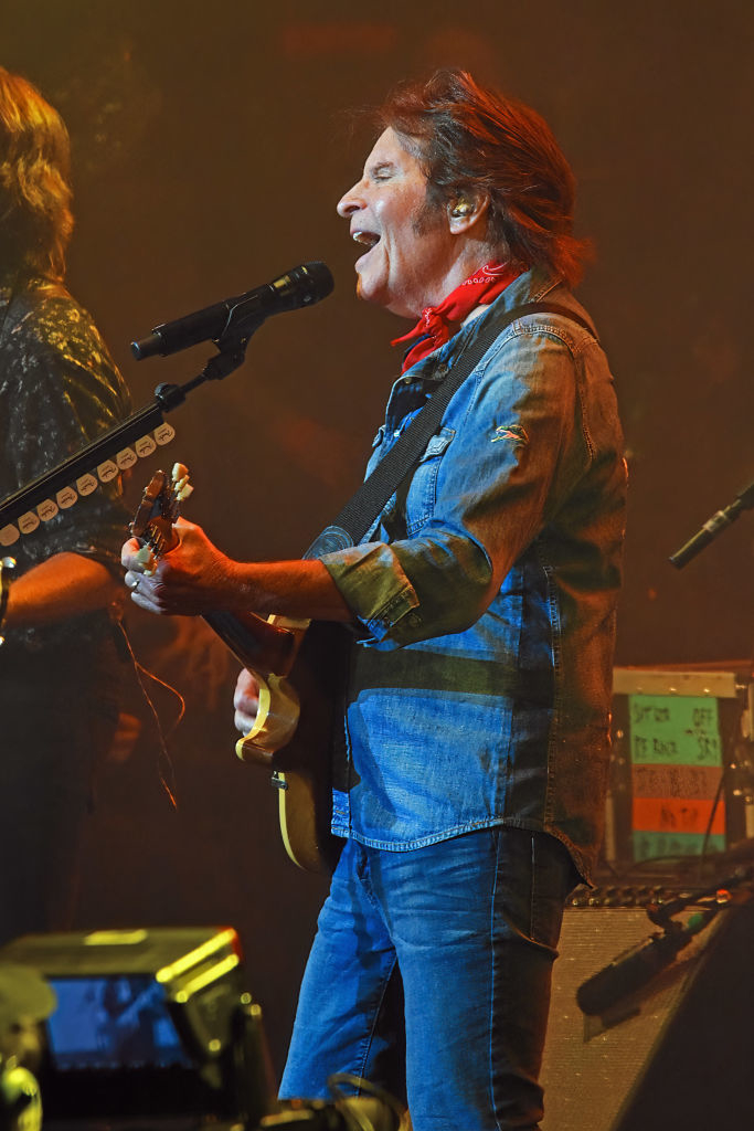 John Fogerty playing guitar and singing on stage