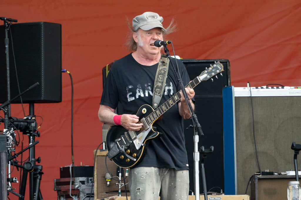 Neil Young plays the electric guitar and sings on stage