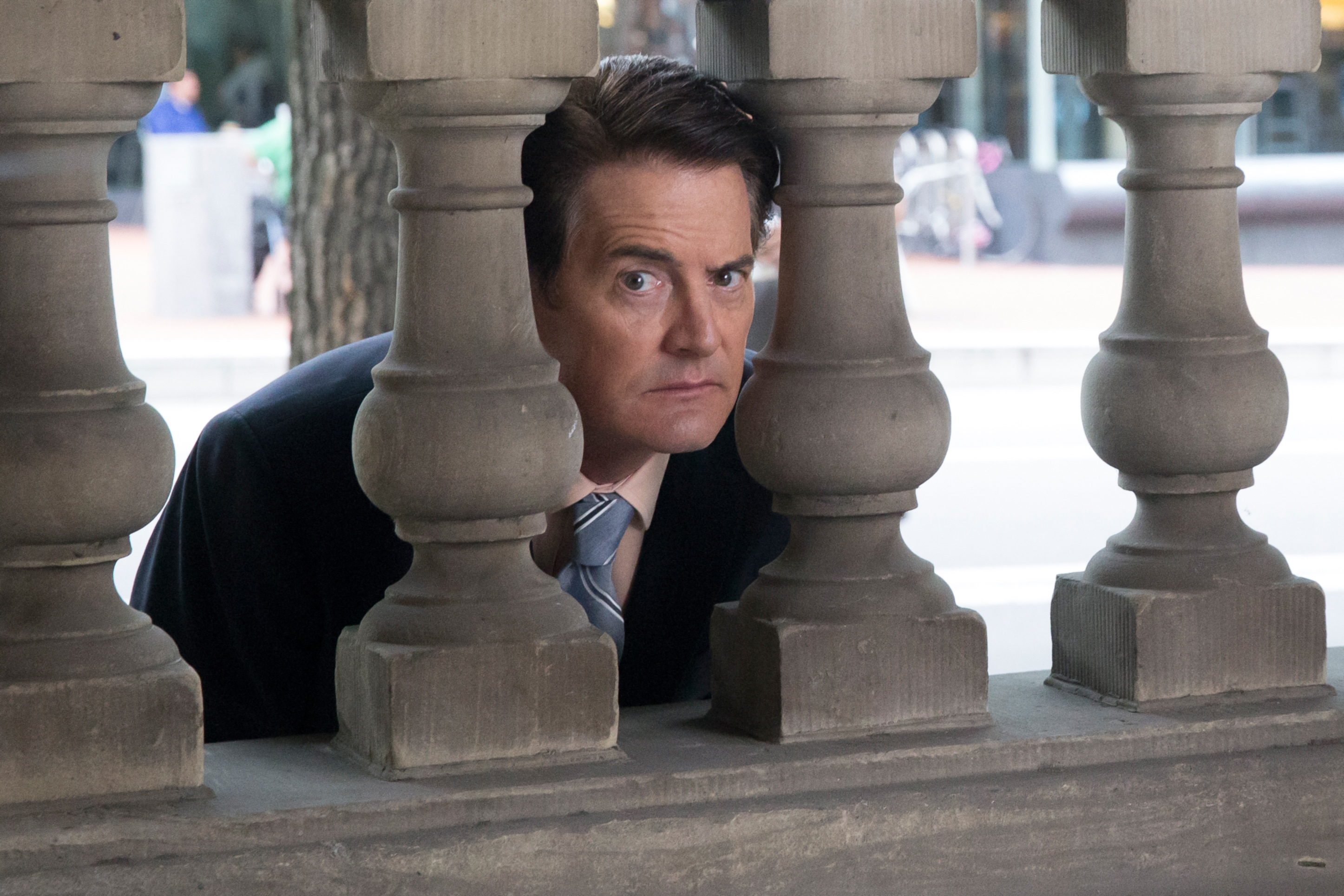 Kyle MacLachlan peeks through a stone fence in "Portlandia"