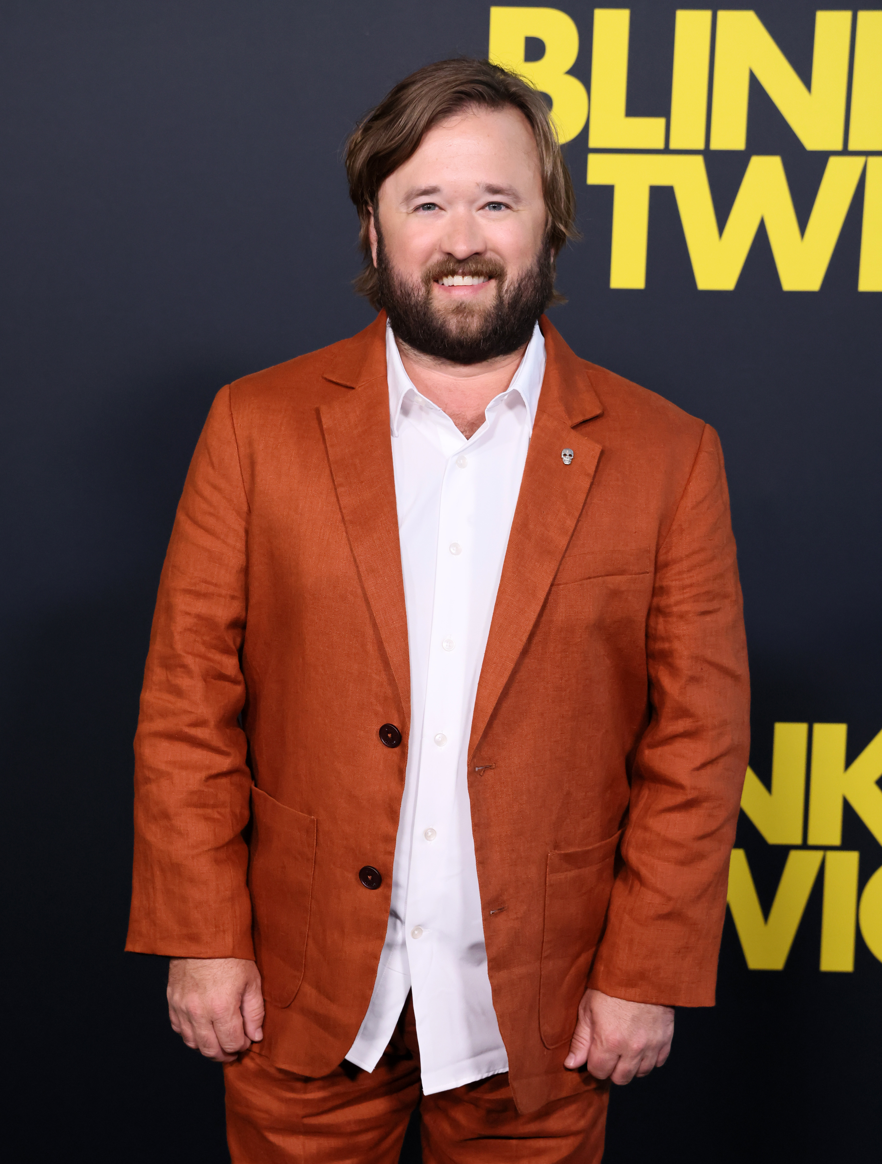 Haley Joel Osment wearing a casual orange suit with a white shirt at the premiere of "Blink Twice"