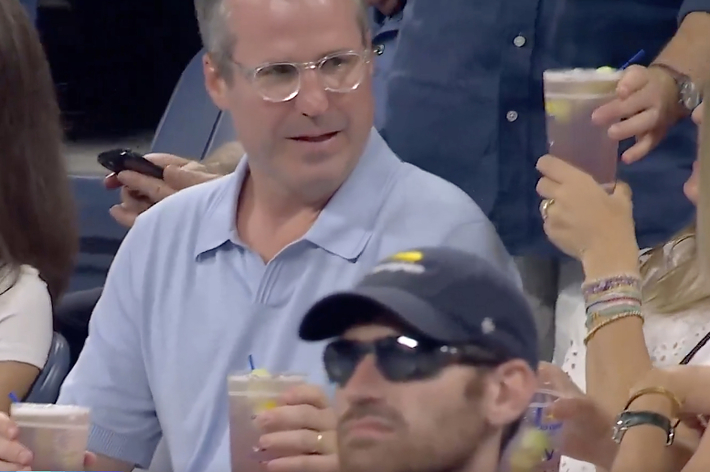 観客席で飲み物を持っている人々。