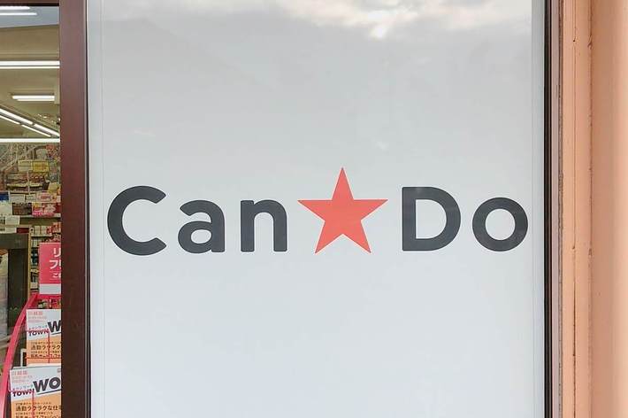 店の入り口の大きな看板には「Can★Do」と書かれています。背景には店内の商品棚が少し見えています。