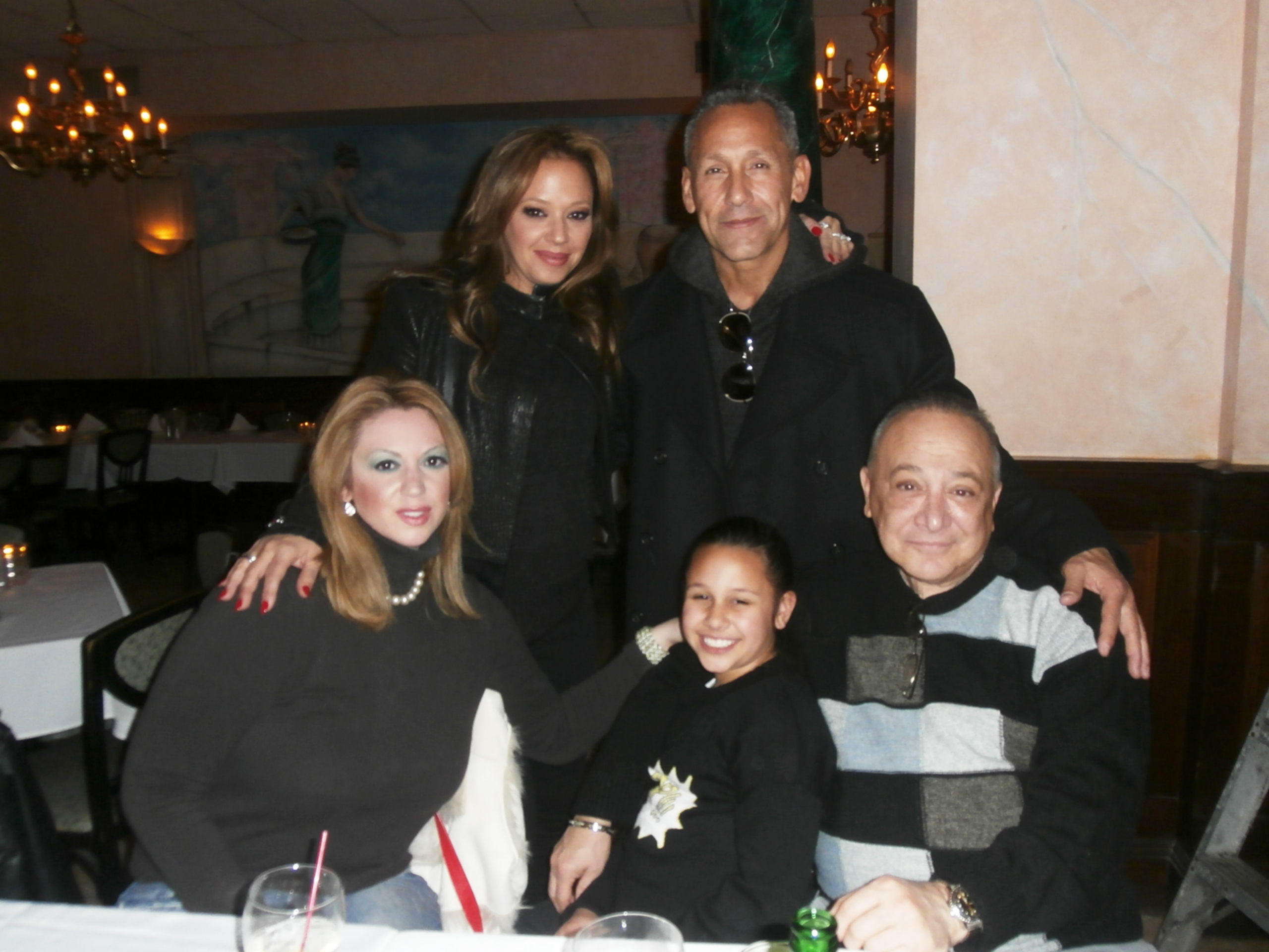 Leah Remini and four others smiling at a dining table in a restaurant