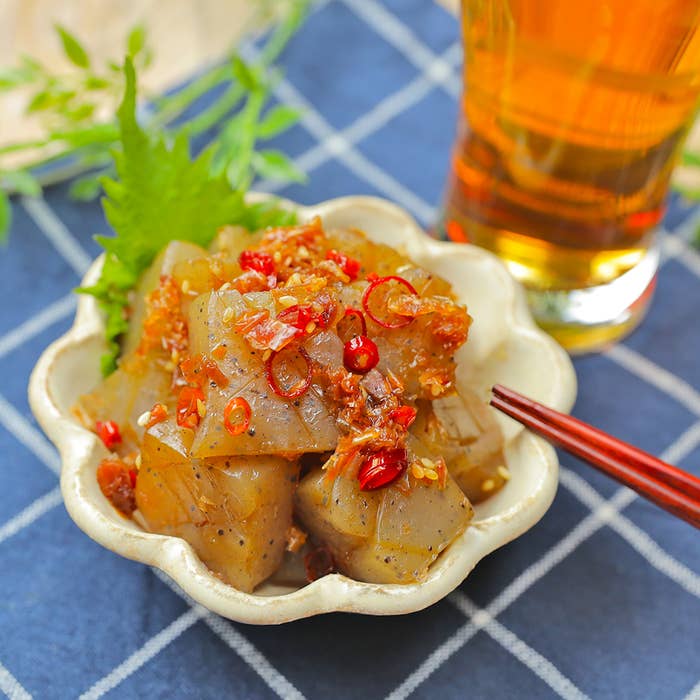 皿に盛られたピリ辛こんにゃくとグラスの飲み物。