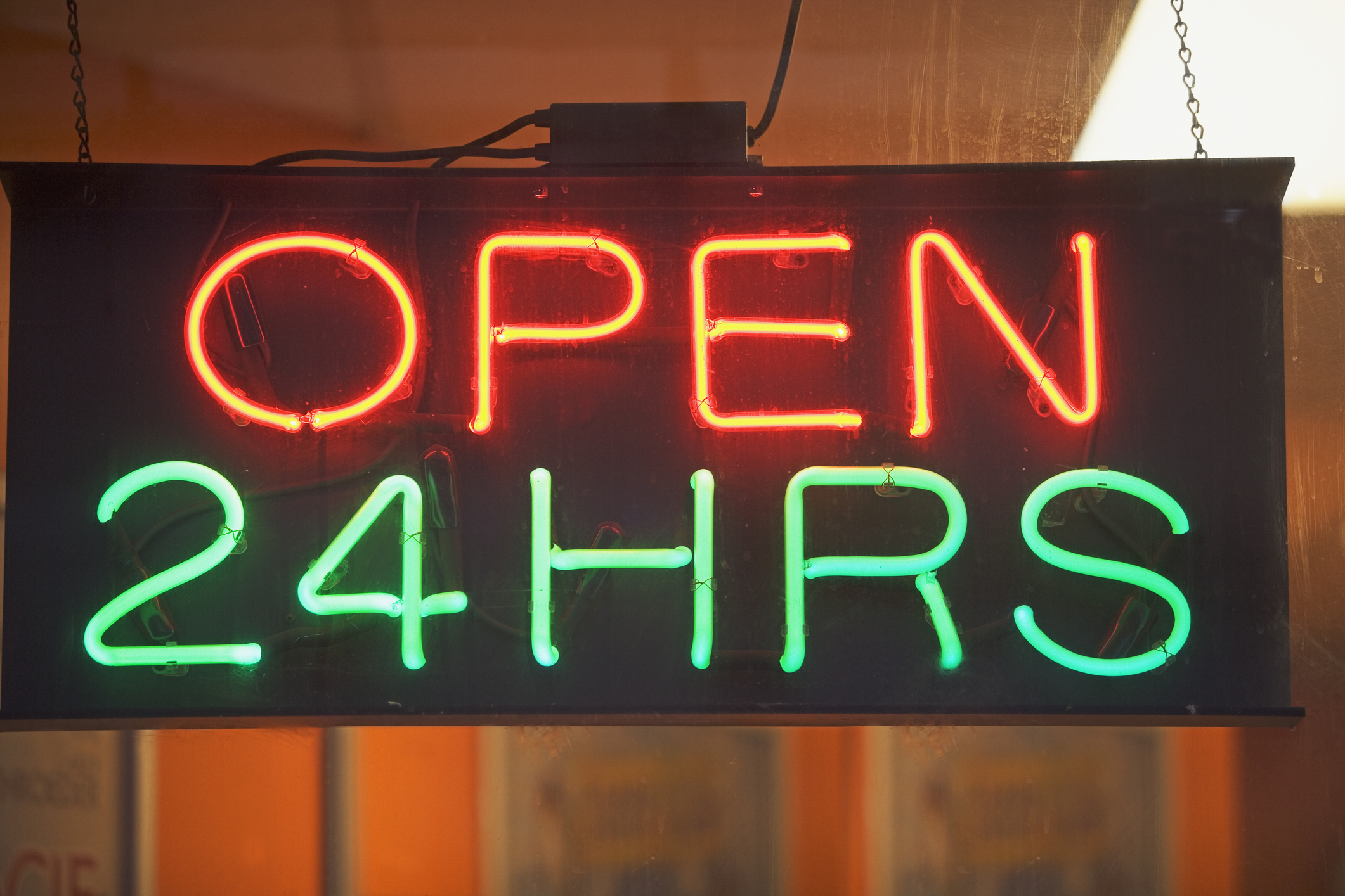 A neon sign displaying the words "OPEN 24HRS."