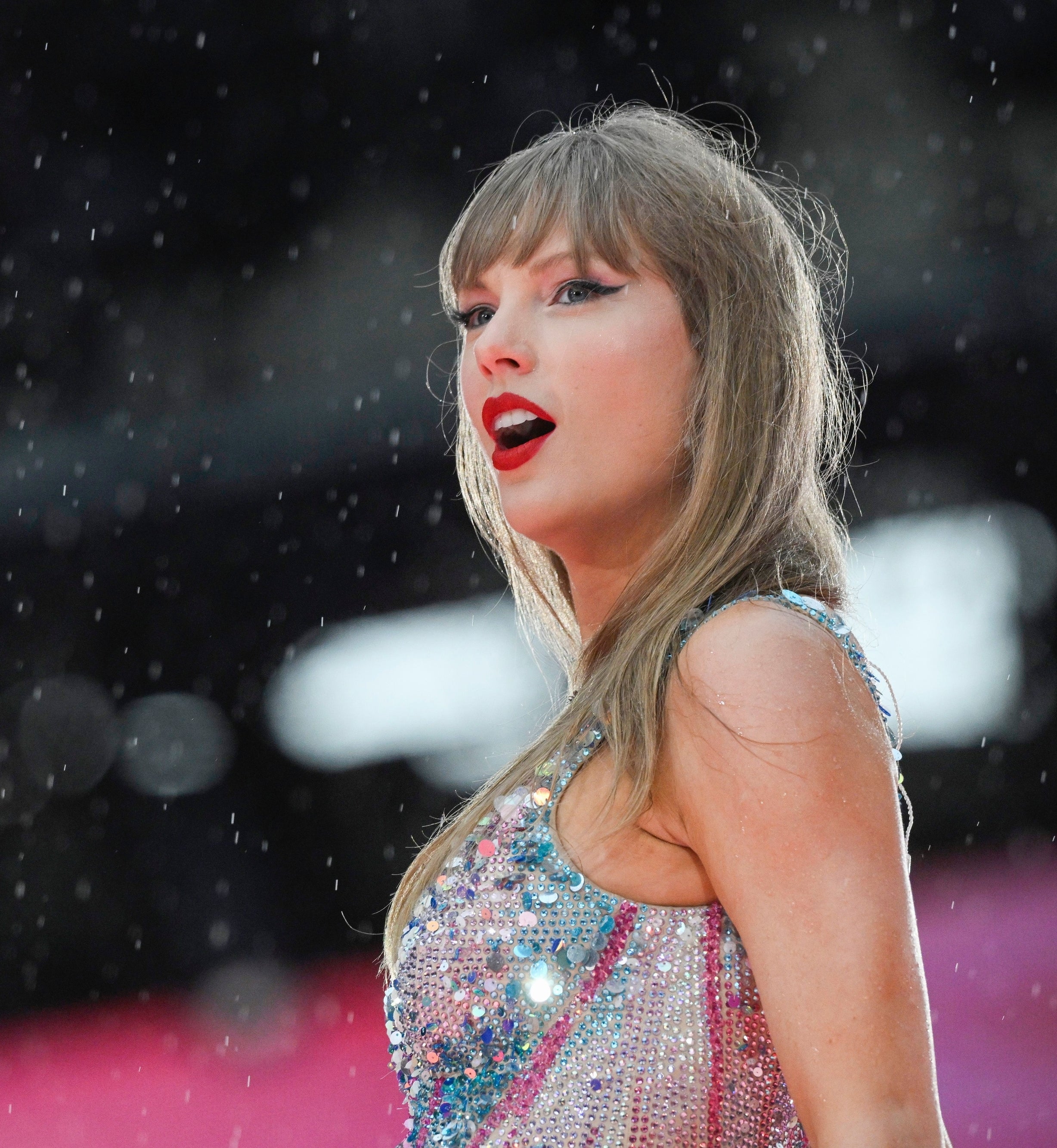 Taylor Swift performing on stage in a sparkling sleeveless outfit