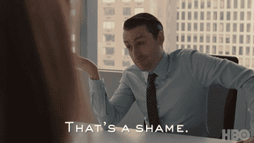 A man in an office setting dismissively shrugs and says, "That's a shame."