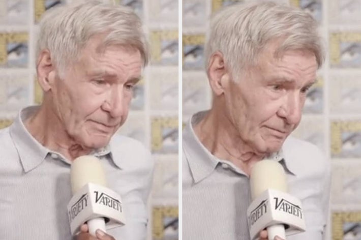Harrison Ford being interviewed by Variety, holding a microphone, standing in front of a backdrop with comic art