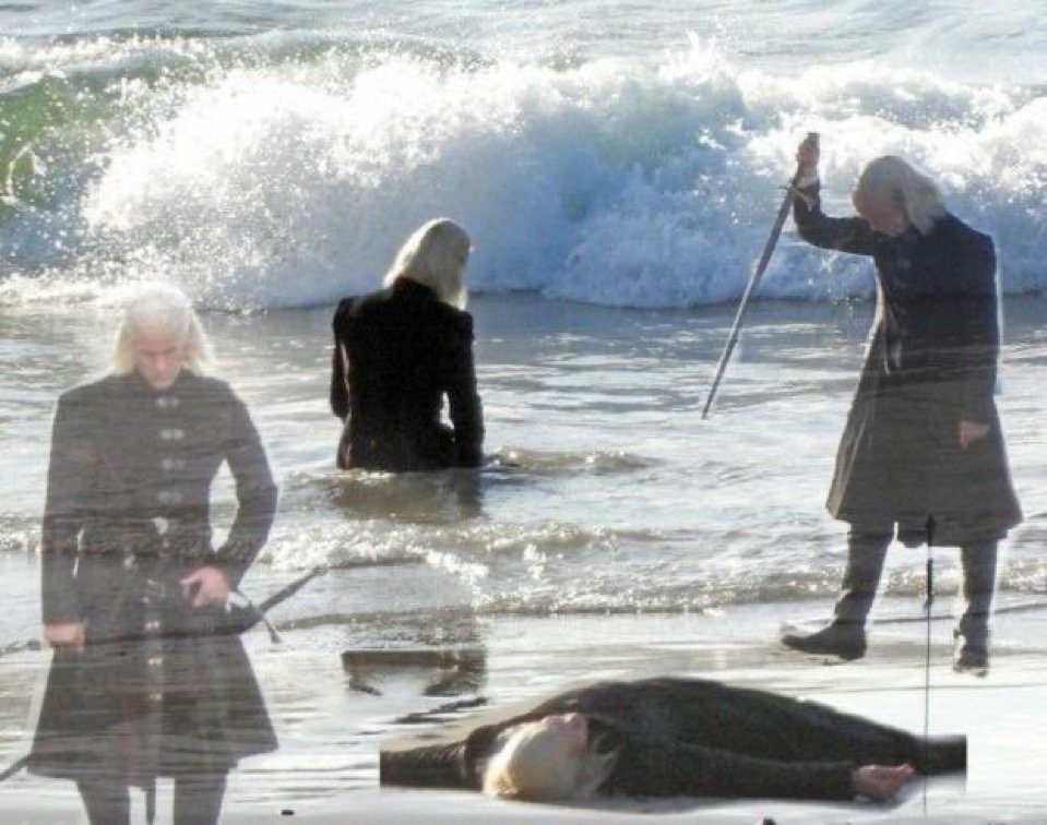 Tres personas con cabello largo y blanco, vistiendo ropas oscuras, en una playa con espadas: una está de pie, otra arrodillada en el agua y otra acostada en la arena
