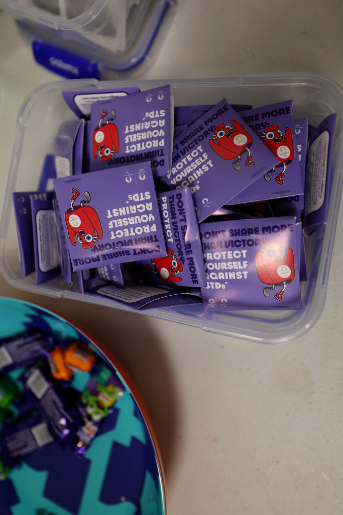 Packets of antibacterial hand wipes with cartoon characters and the slogan &quot;Protect yourself against germs&quot; are displayed in a plastic container