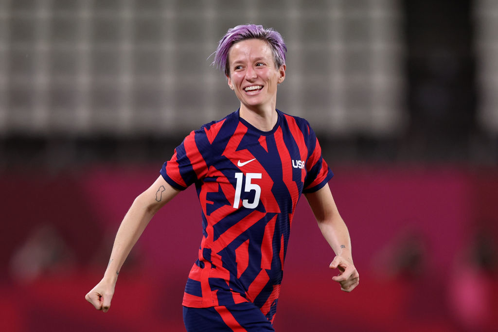 Megan Rapinoe on the field in a USA soccer jersey with number 15, smiling during a match