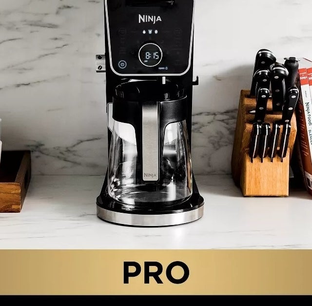 Ninja Pro compact coffee system. Measures 7.08" L x 14.26" D x 15.5" H with reservoir in the back. Pictured with coffee mugs and utensil set on a kitchen counter