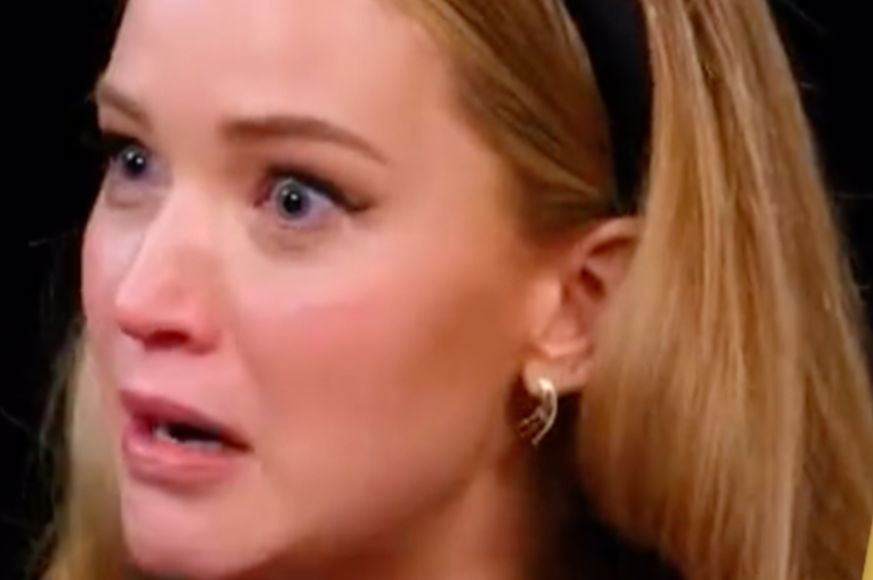 Jennifer Lawrence with a shocked expression, wearing a headband and earrings