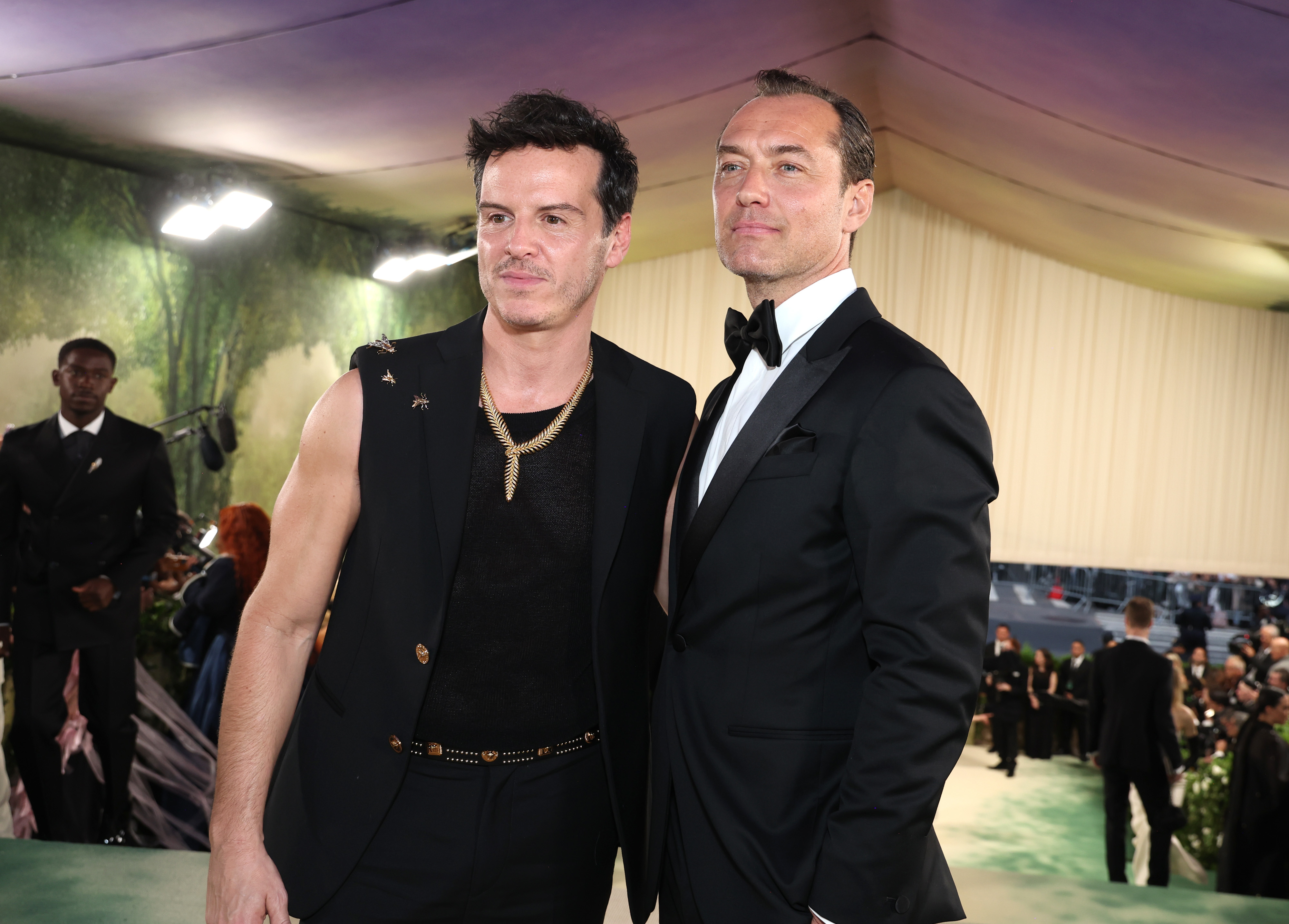 Andrew Scott in a sleeveless outfit and Jude Law in a tuxedo pose together at a formal event