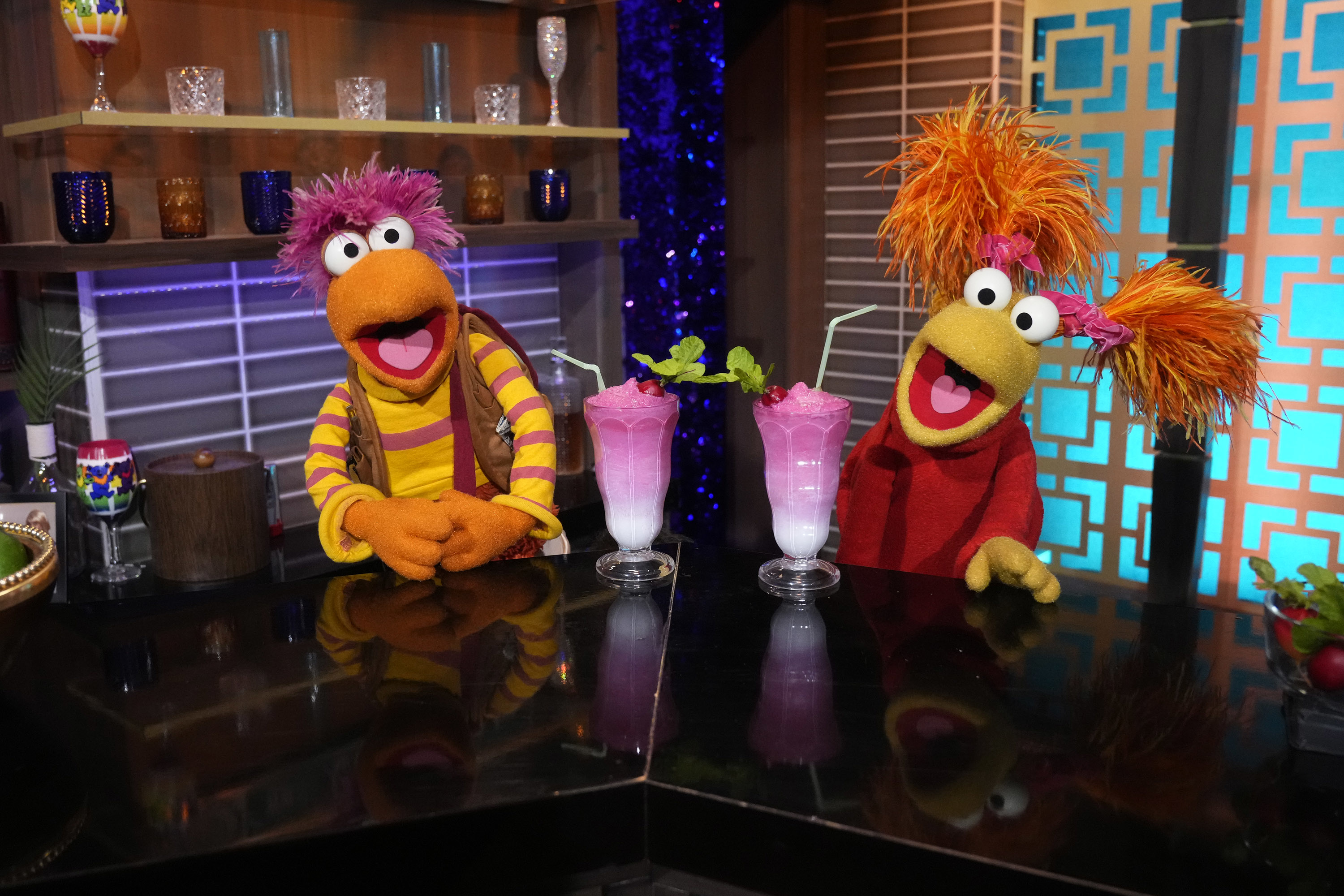 Gobo Fraggle and Red Fraggle from Fraggle Rock are behind a bar counter with two milkshakes in front of them