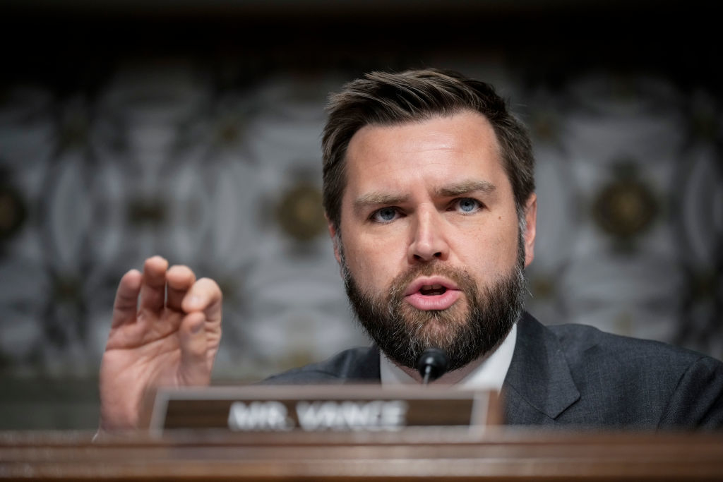J.D. Vance is speaking passionately, gesturing with his hand, during a formal event