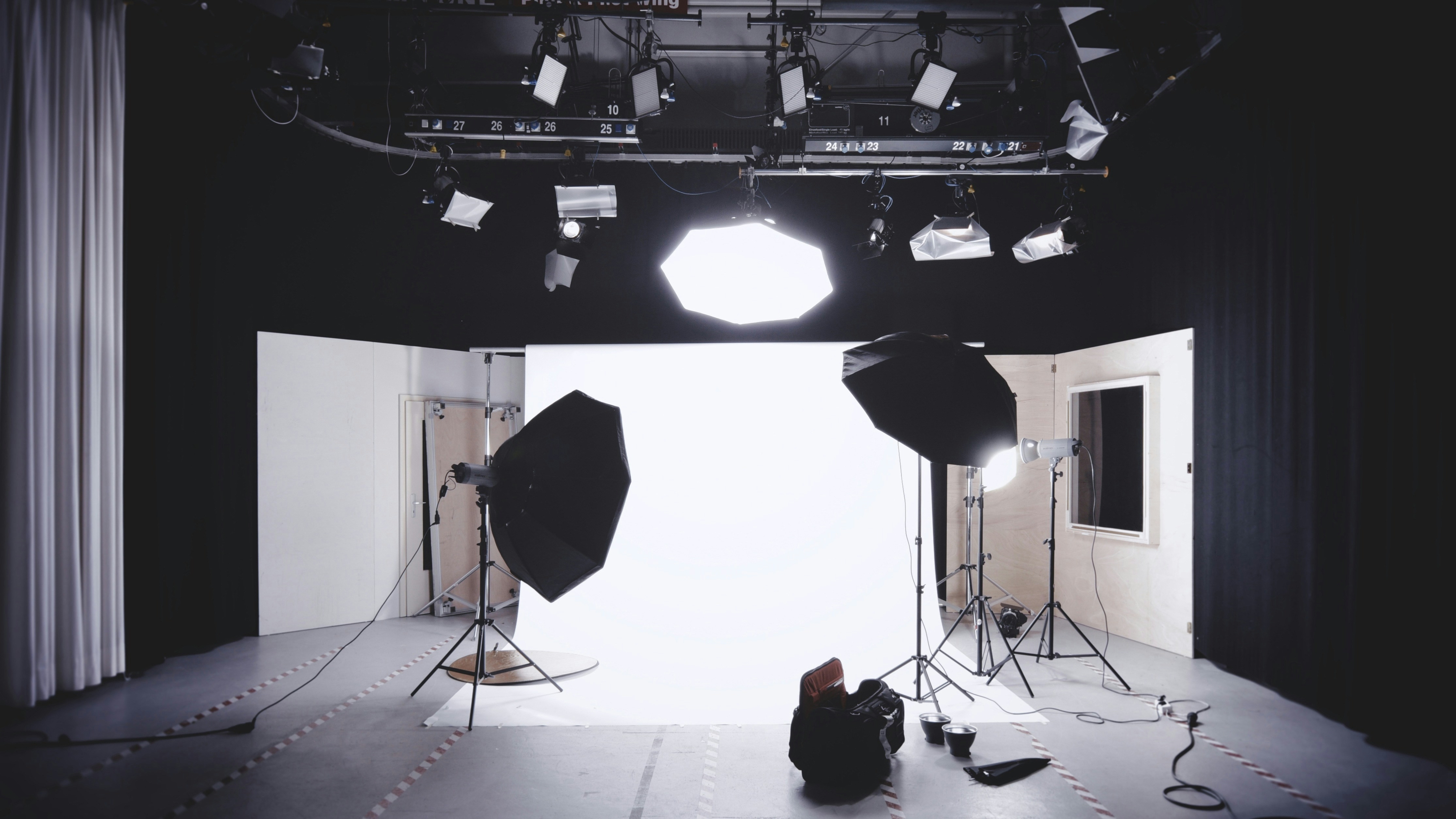 A professional photography studio setup with large lights, softboxes, and a white backdrop, ready for a photoshoot