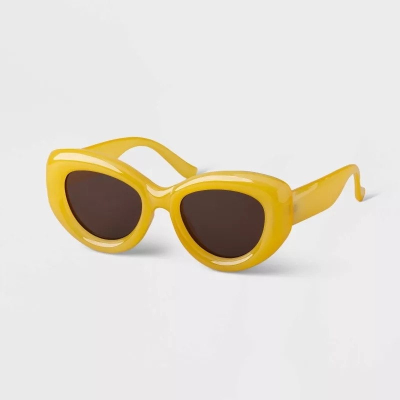 Yellow, retro-style cat-eye sunglasses with dark lenses against a plain background