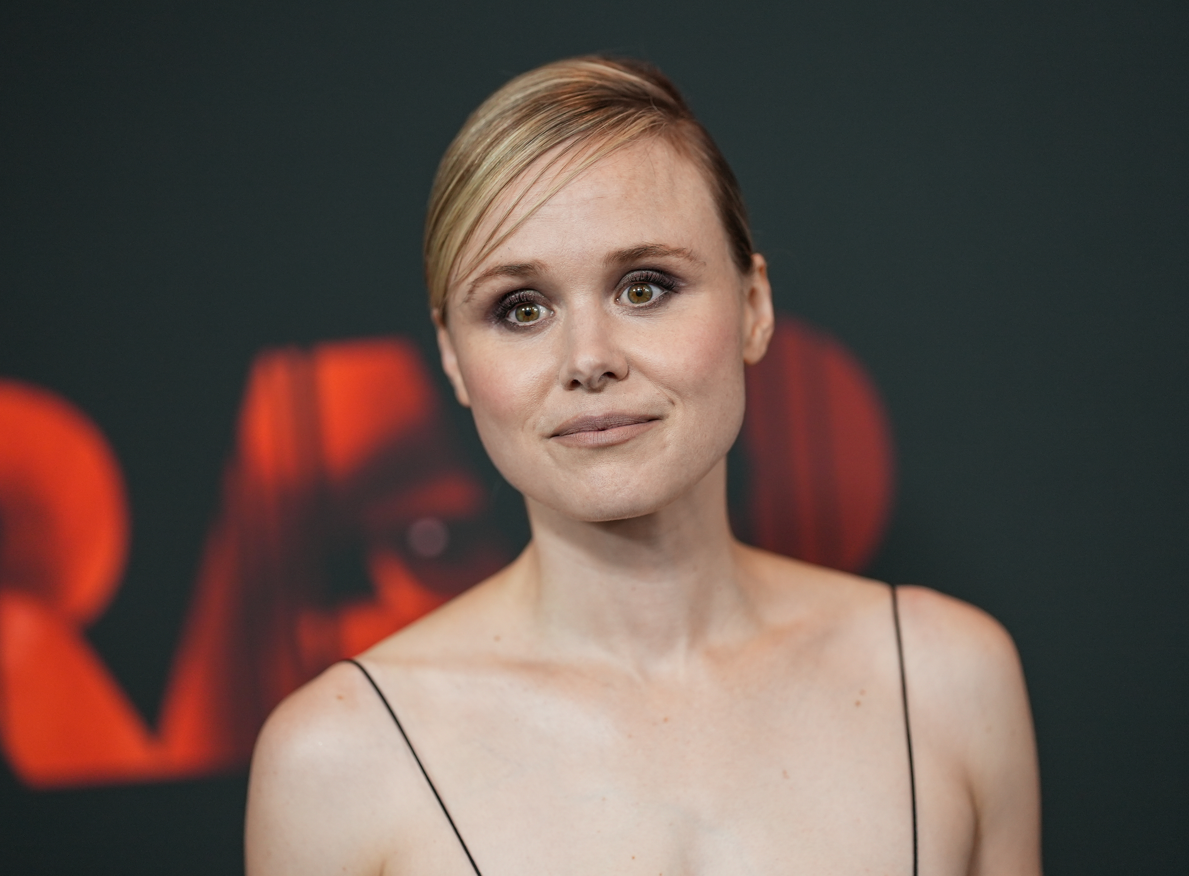 Alison Pill at a red carpet event, wearing a minimalist thin-strapped dress