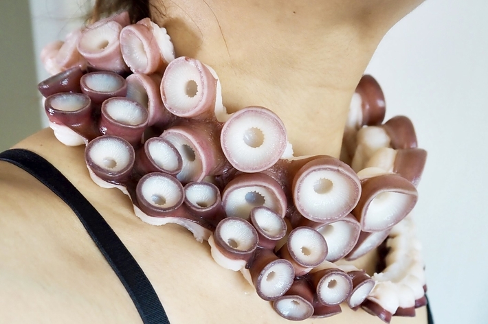 女性の首にイカの足を使った斬新なデザインのネックレスが掛かっている。