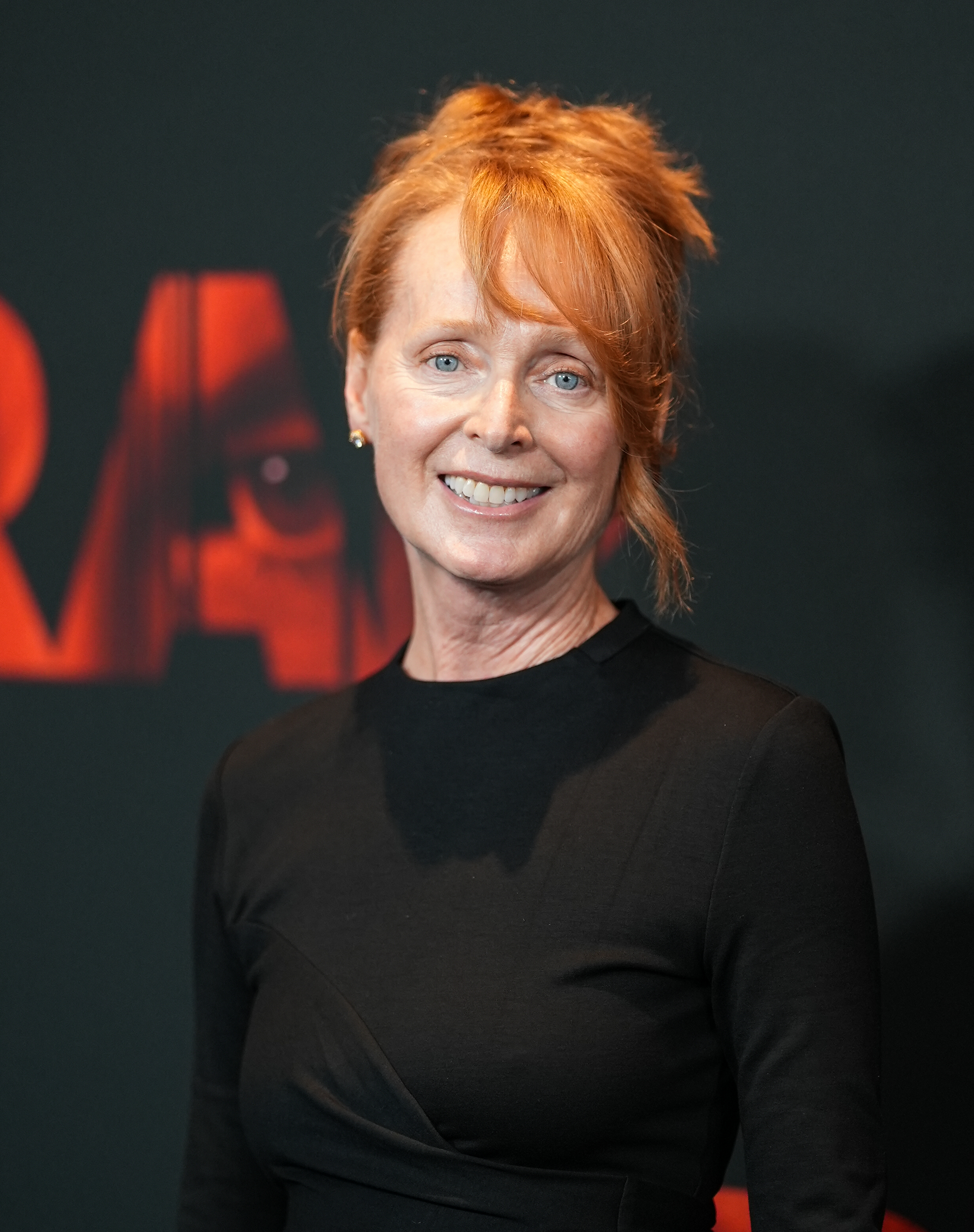 Marnie McPhail wearing a black long-sleeved dress and smiling at the camera