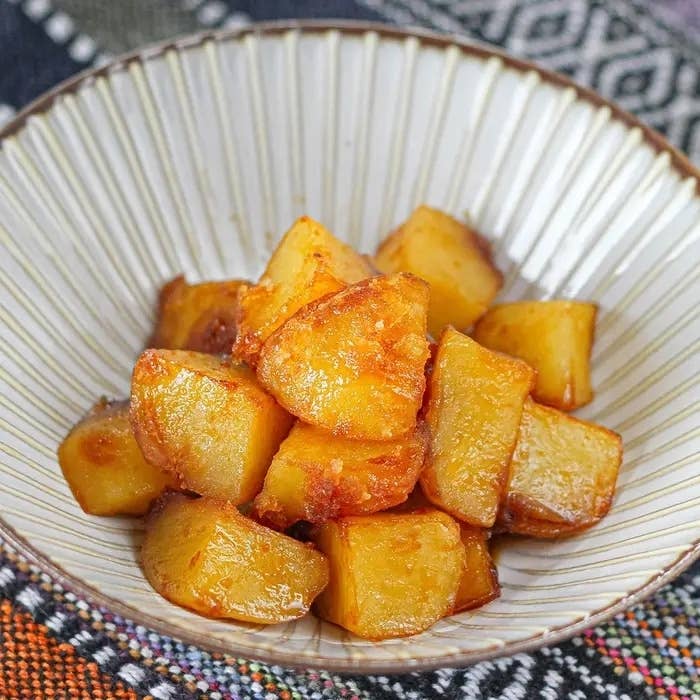 白い皿に盛られたカリカリに揚げられたじゃがいもの一皿。