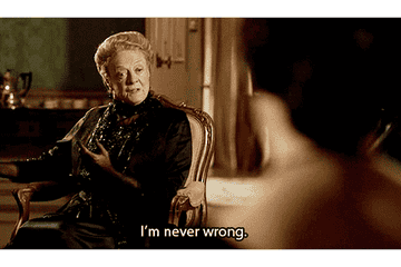 Maggie Smith, in an elegant black outfit, sitting and gesturing, saying, "I'm never wrong," from a scene in Downton Abbey
