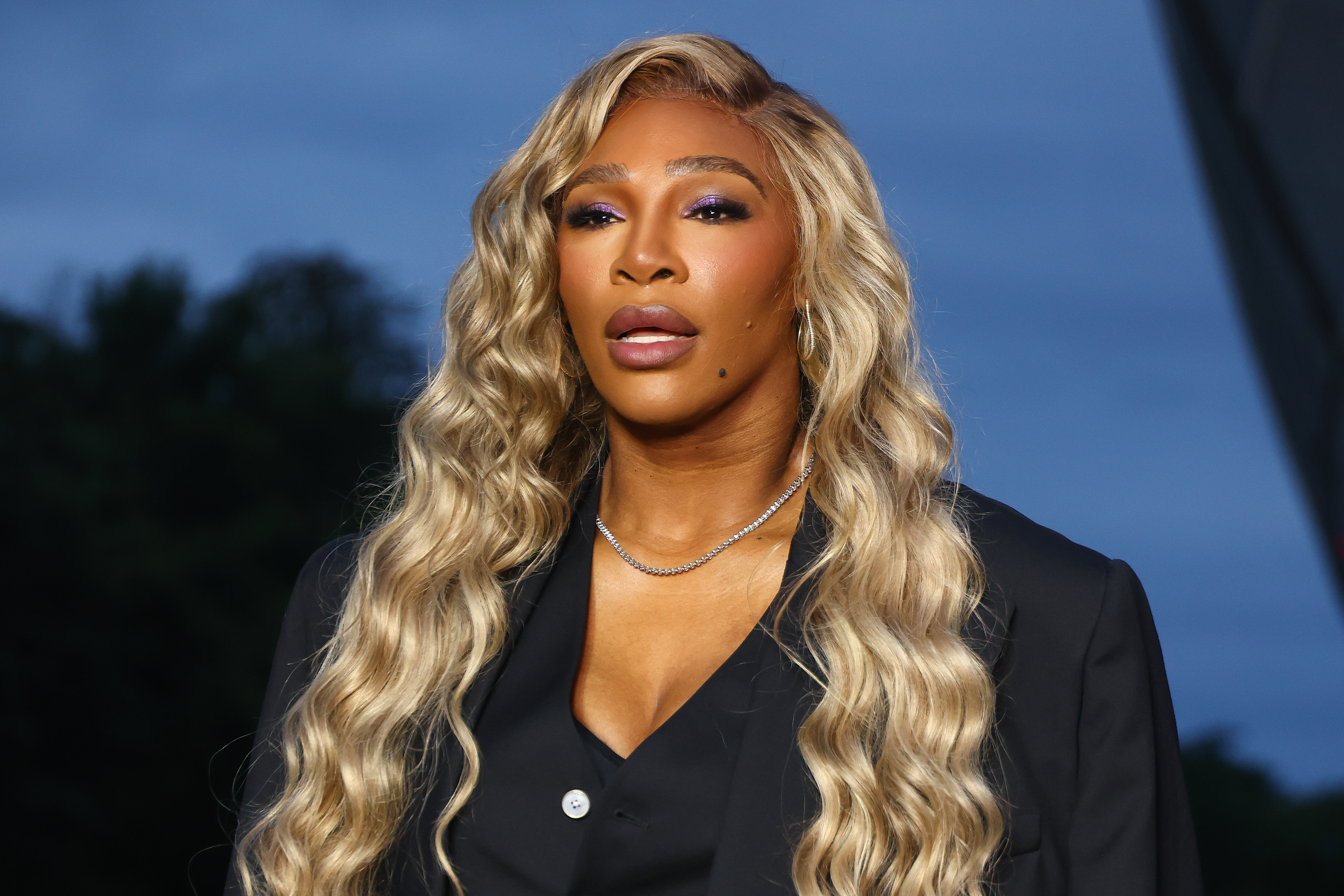 Serena Williams with long, wavy hair wearing a black outfit, looking forward